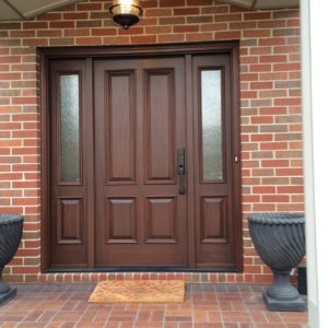 Traditional ProVia front entry door with simulated woodgrain, solid door and two sidelights.