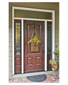 cherrywood front door with decorative glass sidelighes and a glass transom