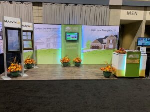 Exhibit booth displays simulated wood-frame Marvin windows and graphics