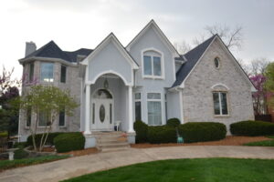 Beautiful two-story home with lots of different window styles, including round-top, casement, and arched