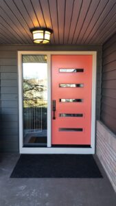 Modern design Hibiscus-colored ProVia front door with a clear-pane sidelight 