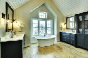 Luxury bathroom with large picture windows flanked by double-hung windows and topped with a smaller picture window with grids in a luxury bathroom behind a soaking tub