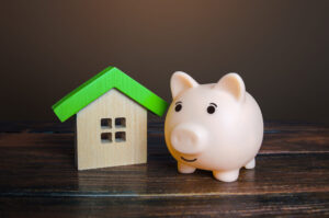 Piggy bank near a house picture illustration for energy tax credits for windows and doors 