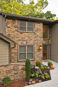 Marvin Wood Ultrex replacement windows shown on exterior home facade with coordinating stone veneer siding